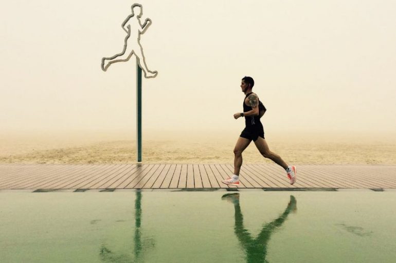 ragazzo fa jogging sulla spiaggia di dubai