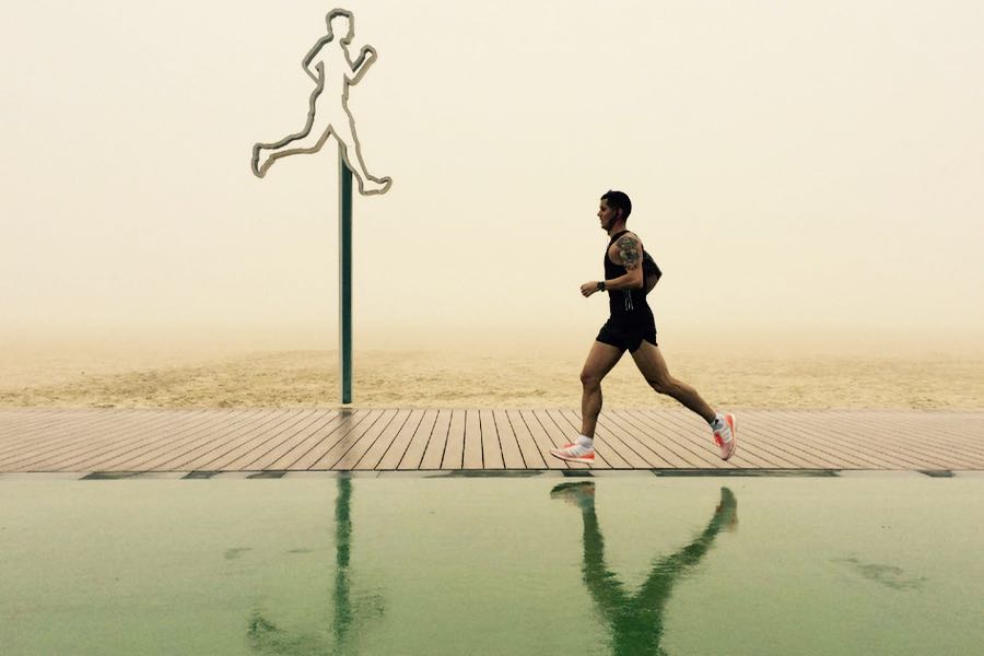 ragazzo fa jogging sulla spiaggia di dubai