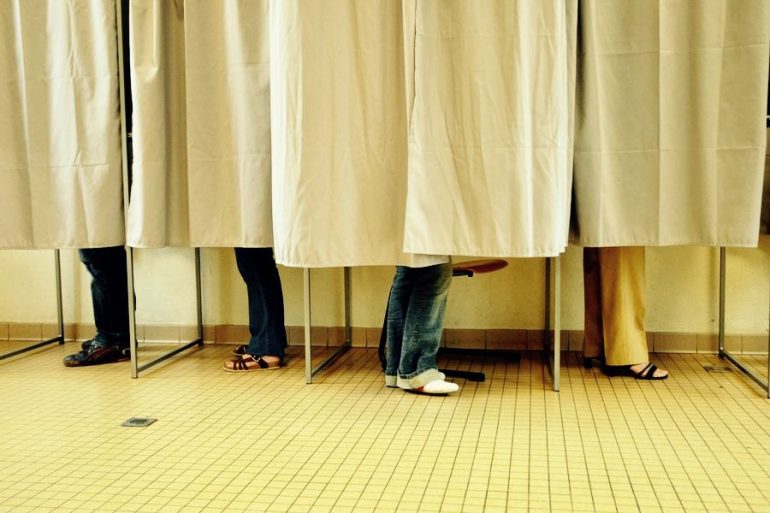 elettori nelle cabine elettorali francesi