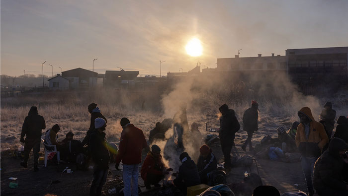 I rifugiati si svegliano dopo aver dormito su coperte e cartone per terra sul lato polacco del valico di Medyka. foto Natalie Keyssar per @ TIME.com